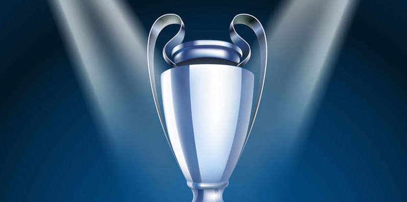 The Champions League Trophy on a Pedestal With a Football Stadium Backgrond