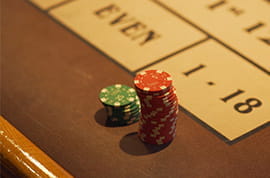 Red and Green Casino Chips at a Roulette Table