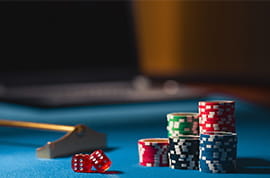 Green, Blue, Red, Black Chips and Red Dice at a Casino Table