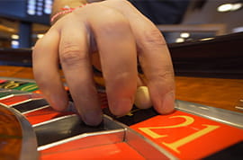 Male Hand with the Roulete Ball Inside the Wheel