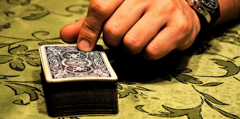 A Man About to Turn Over the First Card of a Deck of Cards