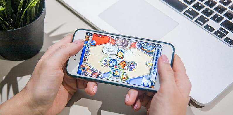 A Man Playing Hearthstone on His Phone 