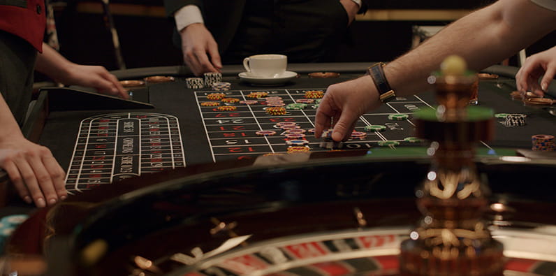 Roulette Dealer Takes the Losing Bets at a Live Roulette Table