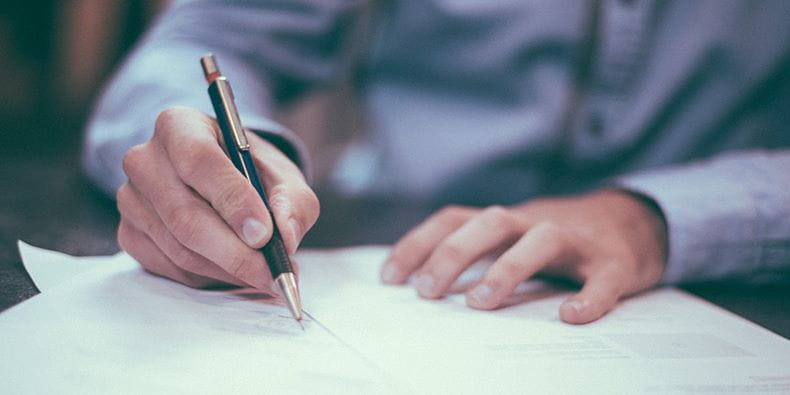 Person Writing on a Sheet of Paper