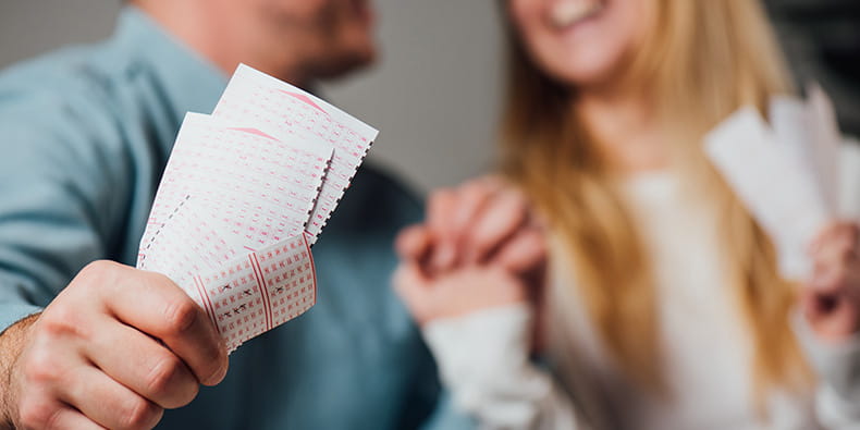 hombre y mujer con boletos ganadores