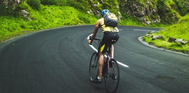 A Person Riding a Bicycle Across a Mountain Road