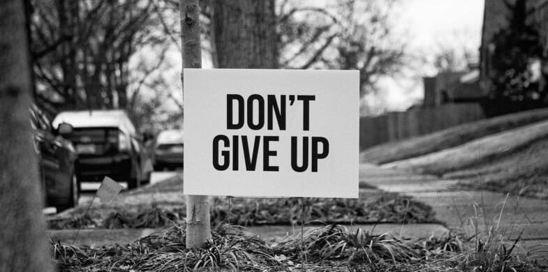 A Black and White Image, Showing a Sign That Says "Don’t Give Up"