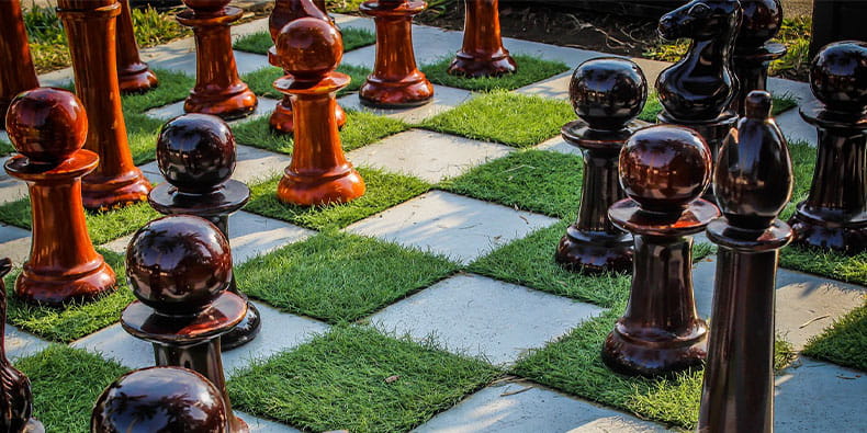 Chess Pieces connected Grass Covered Playing Board