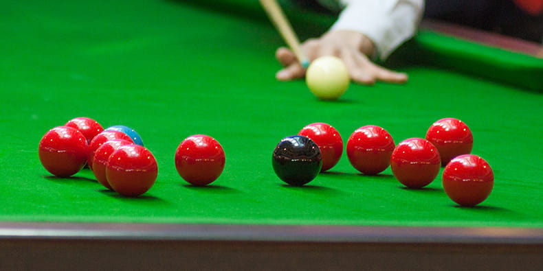 Snooker Player Getting Ready to Hit a Red Ball