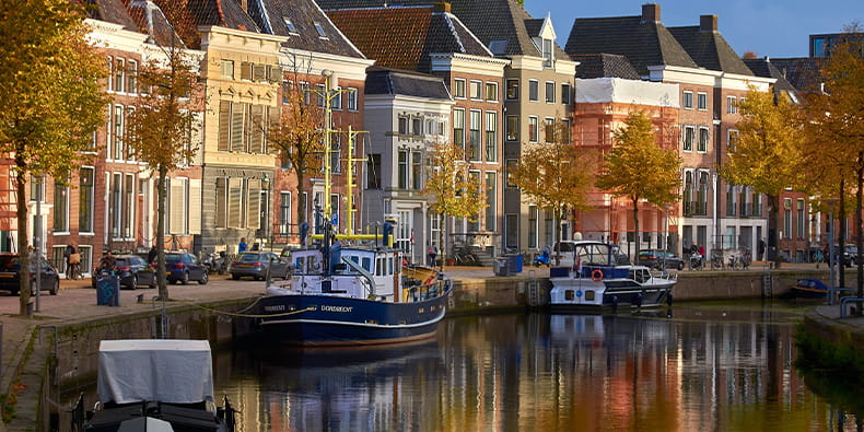 River With Boats And Buildings Behind It 