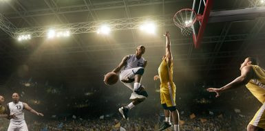 An NCAA Player Doing A Slam Dunk During A Past March Madness Tournament.