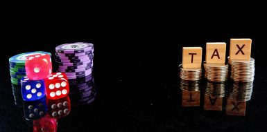 Smartphone showing an online casino game next to a calculator and casino chips